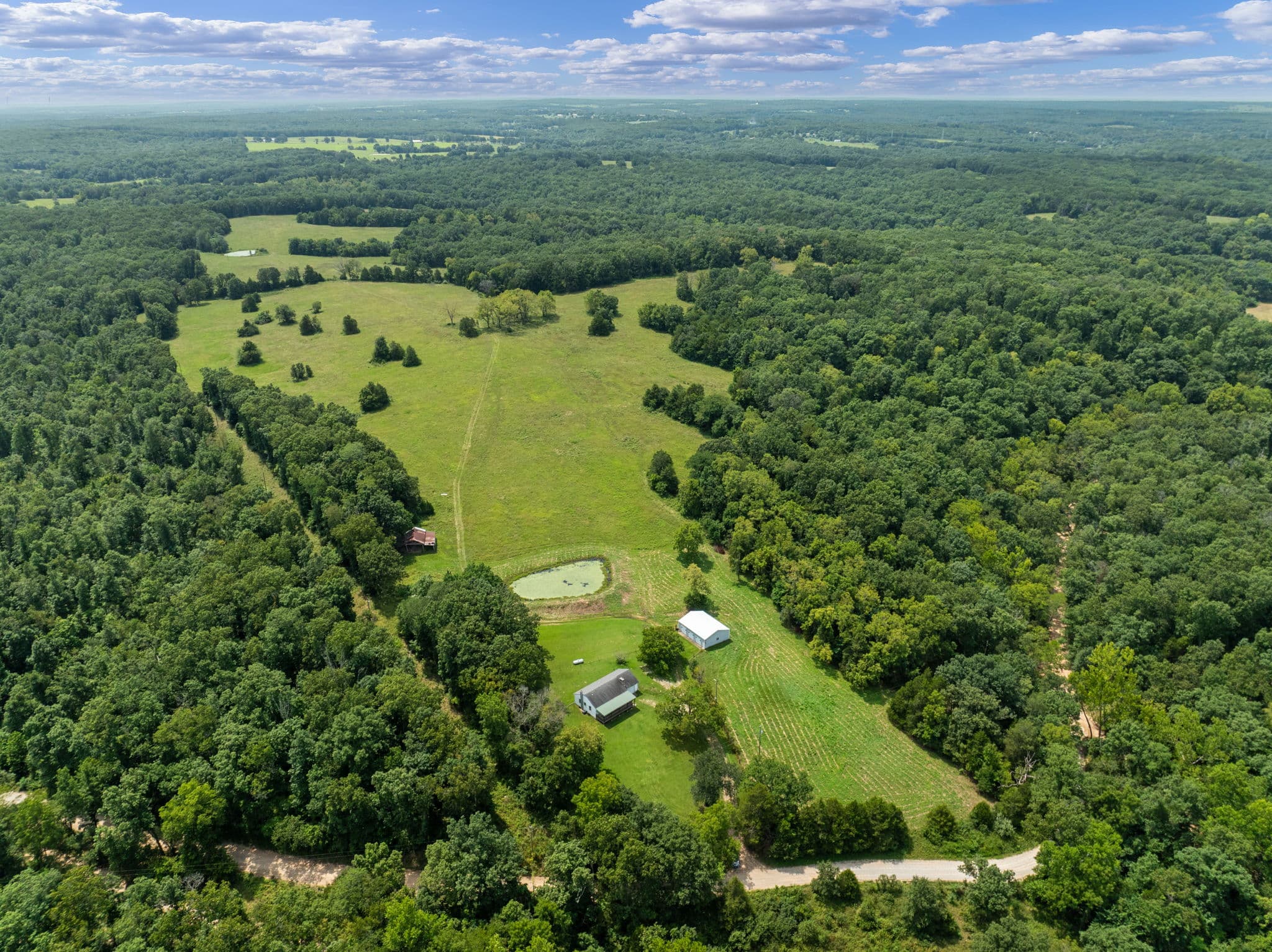 Aerial of the ranch pasture, pond, and homestead buildings
