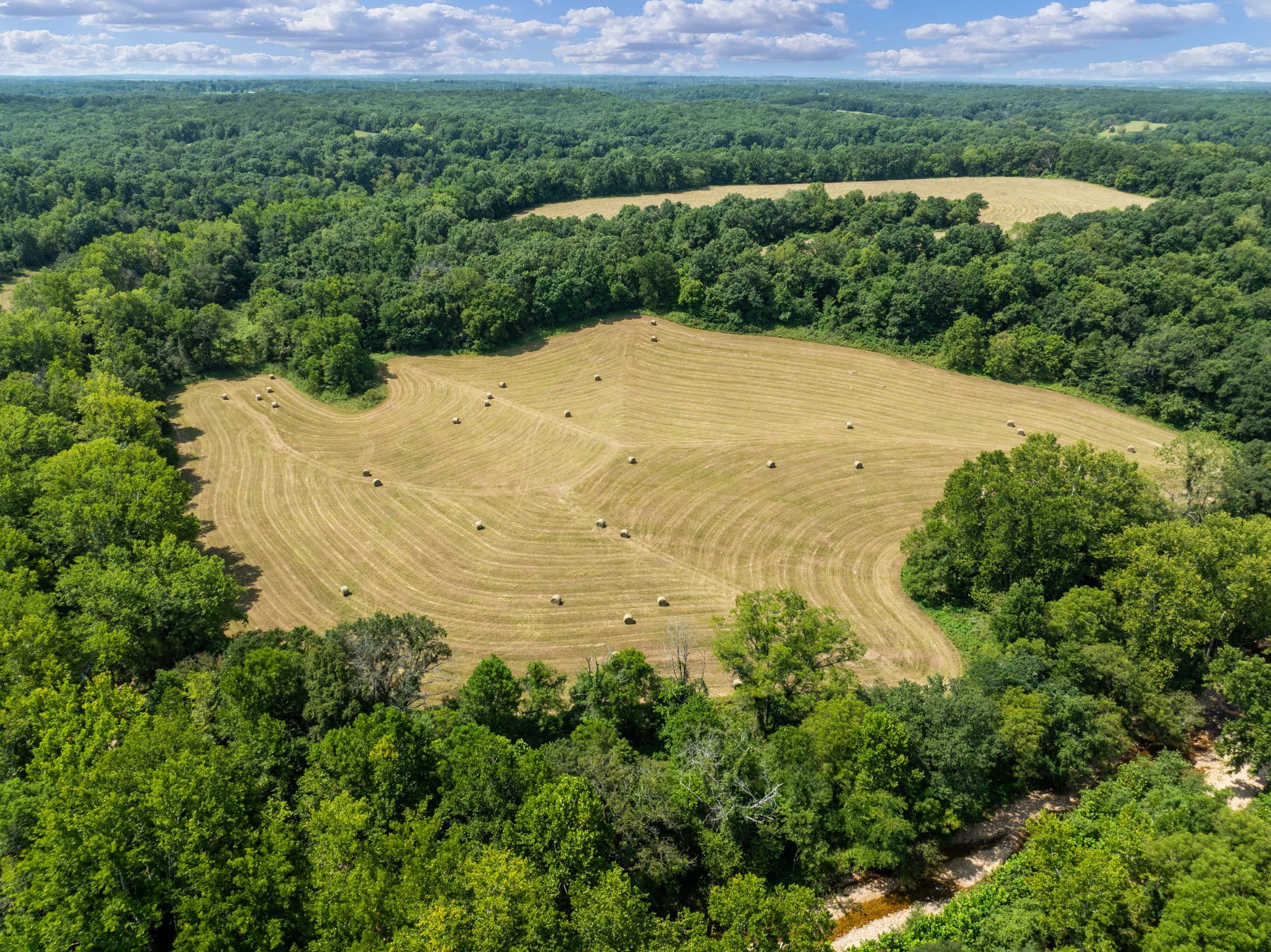 Aerial of a cut hay field with round bales