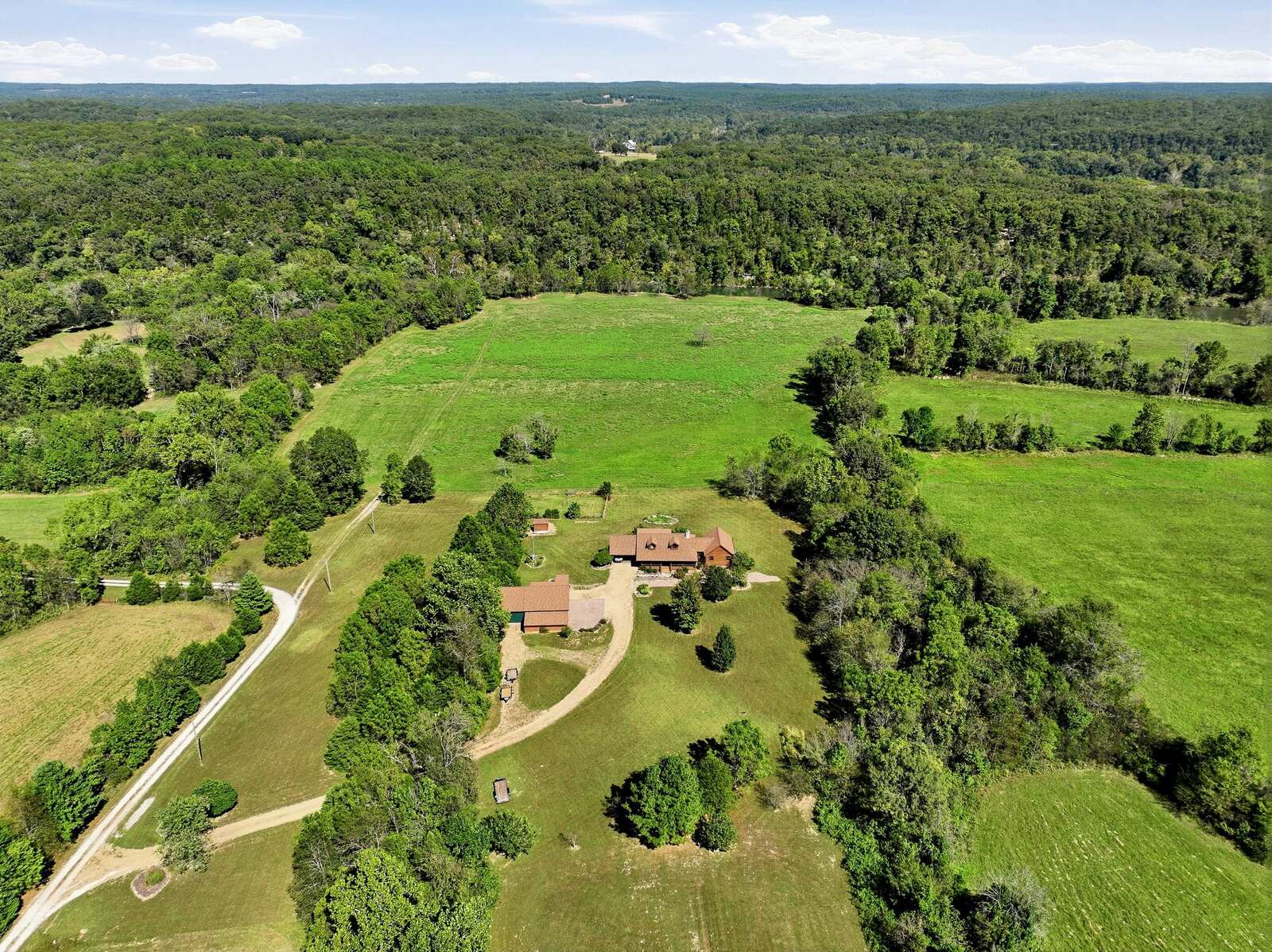 Aerial of the log home, drive, and open acreage at Meramec Trails