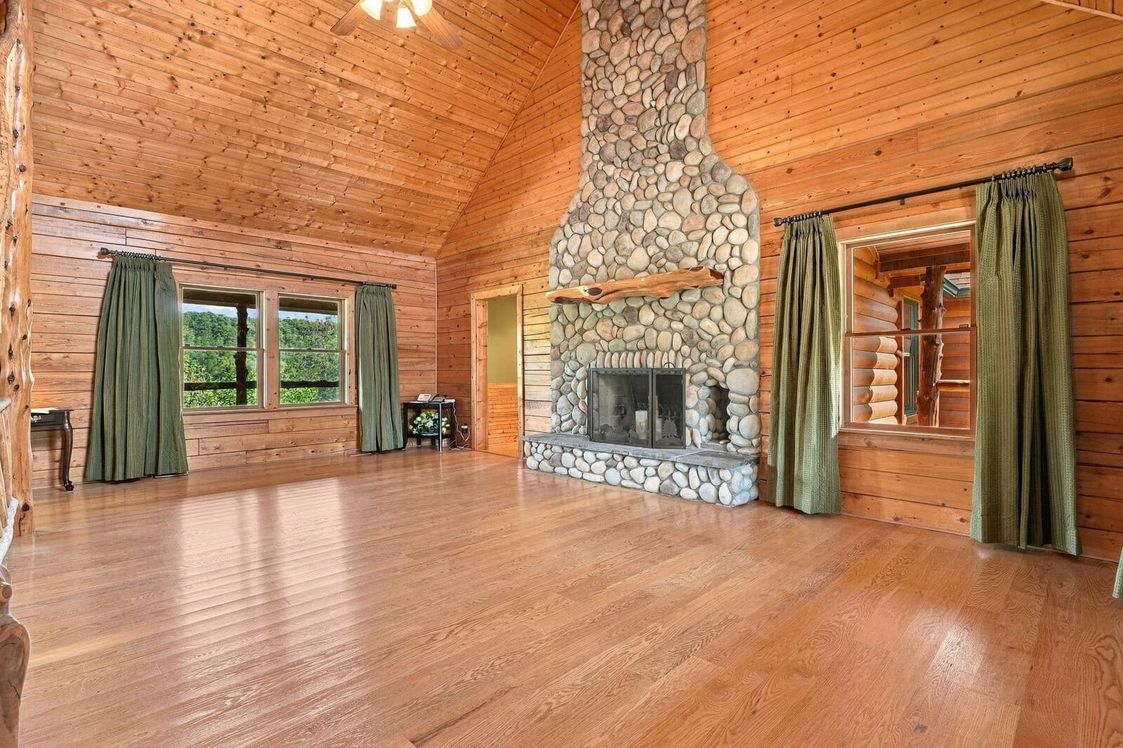 Great room with stone fireplace and hardwood floors