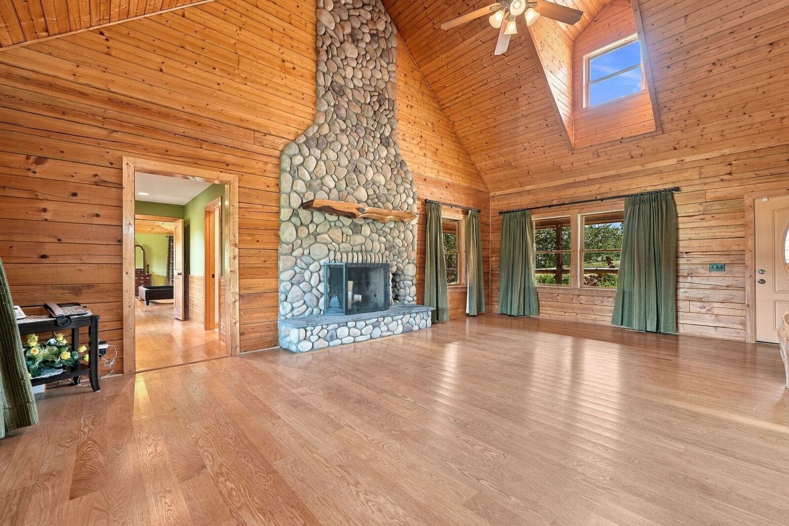 Great room fireplace and windows overlooking the property