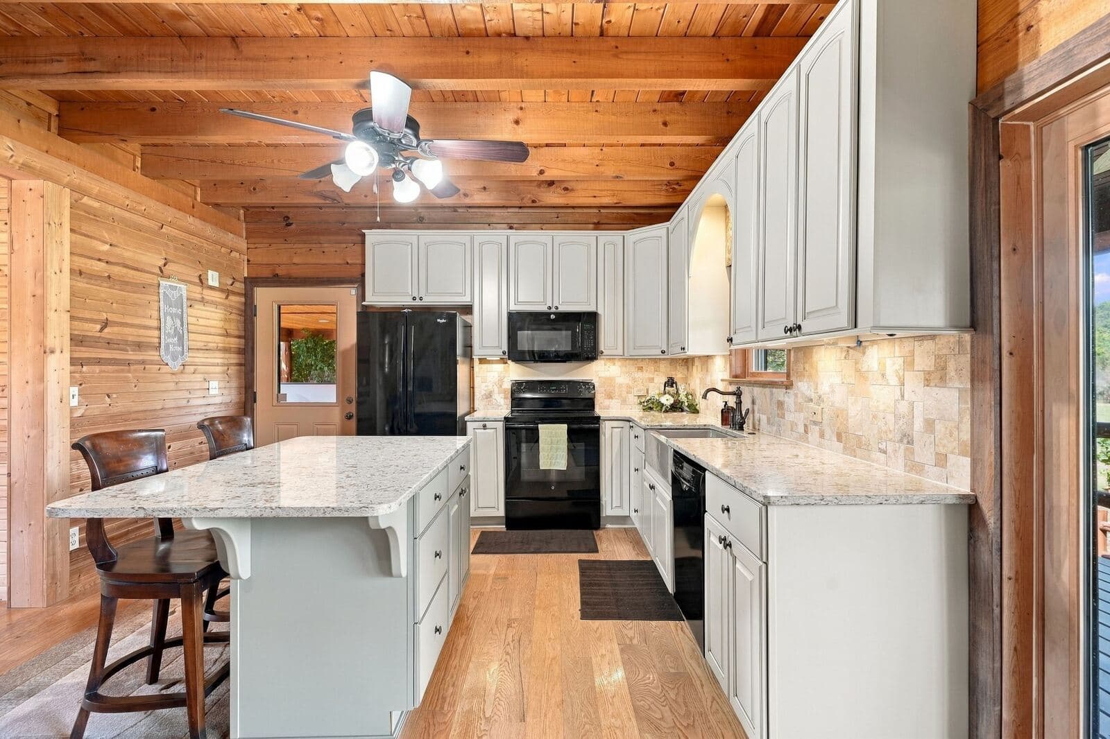Updated kitchen with island and stone backsplash