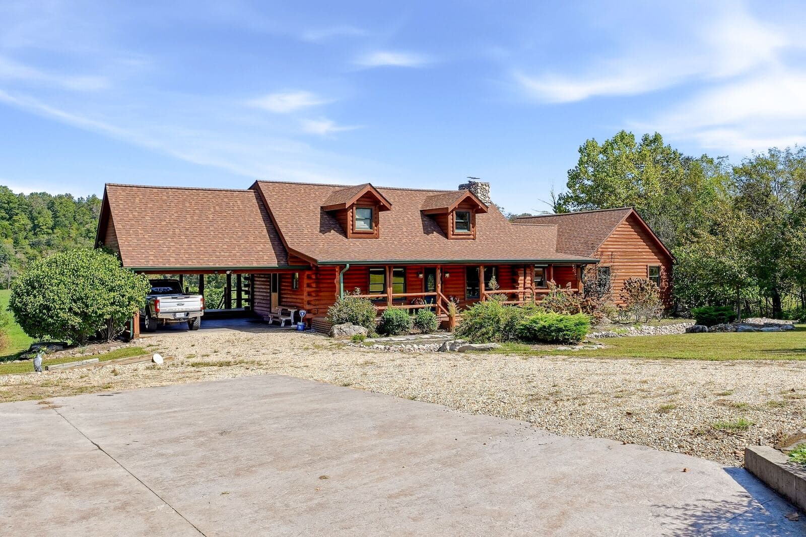 Front of the log home and gravel drive at Meramec Trails