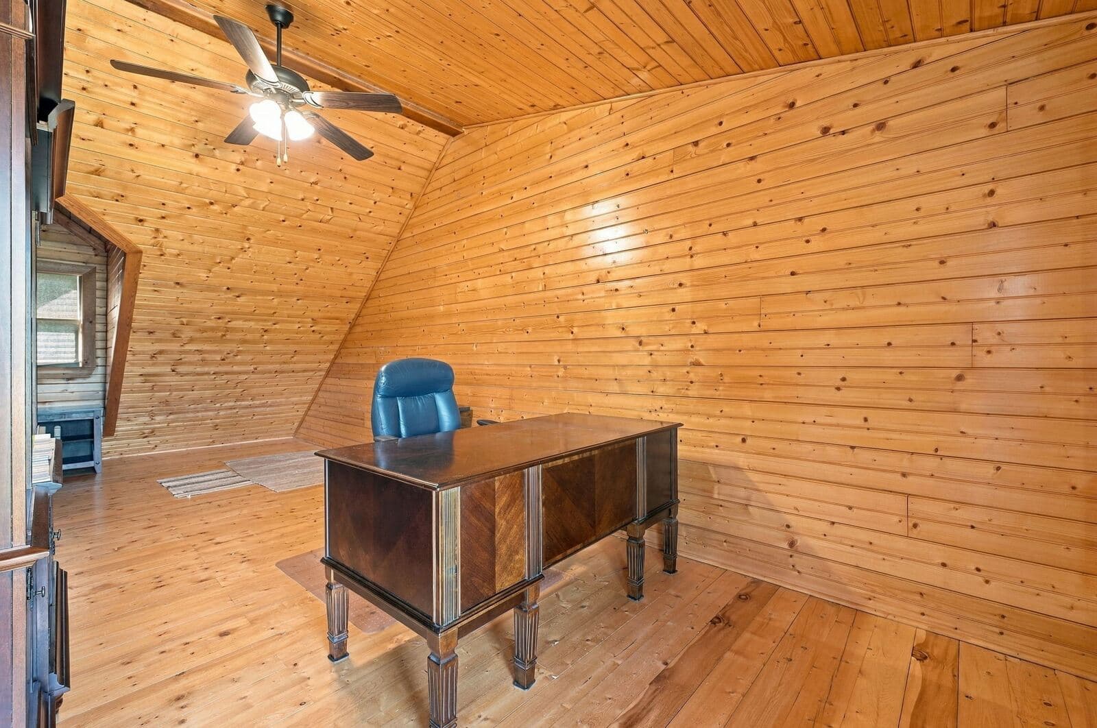 Upstairs room with pine walls and ceiling fan