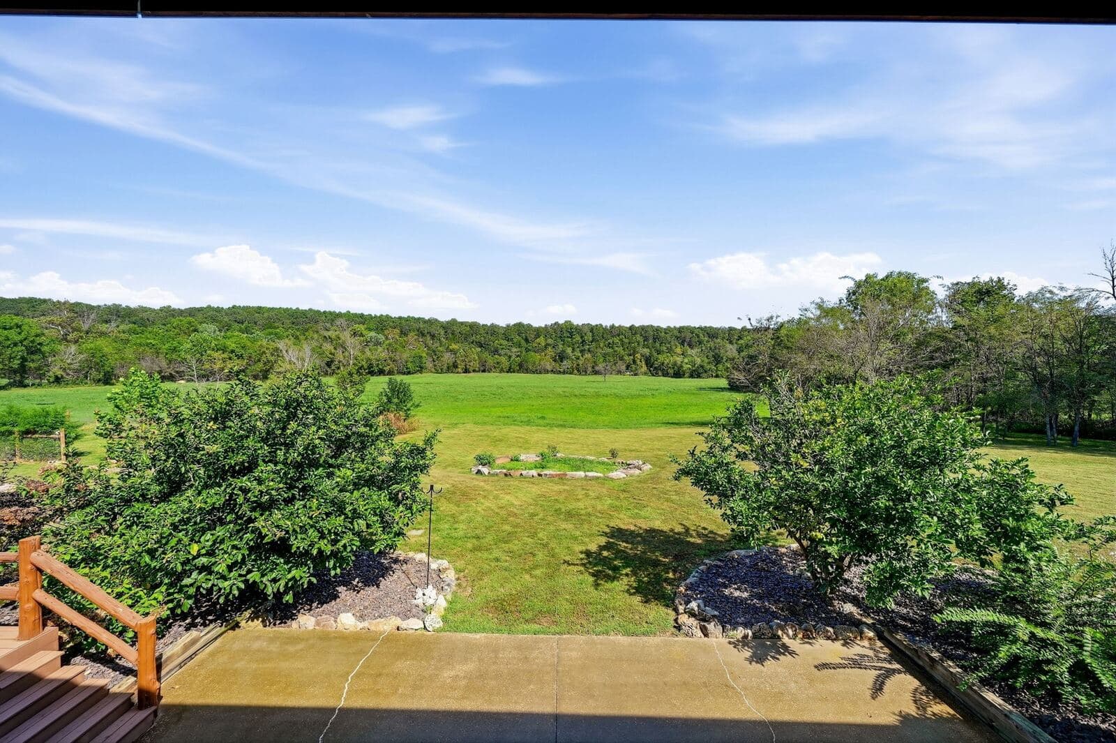 View from the porch across the open field to the timber