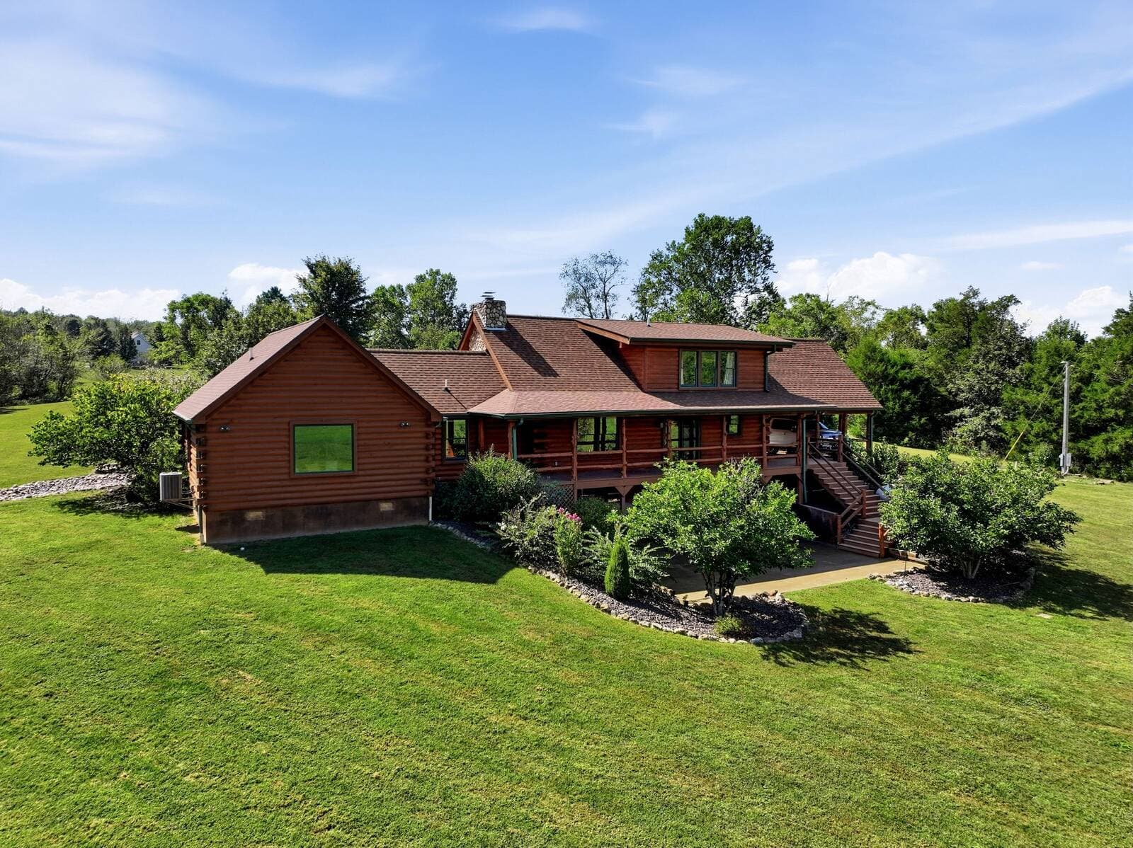 Aerial of the log home set in the open lawn