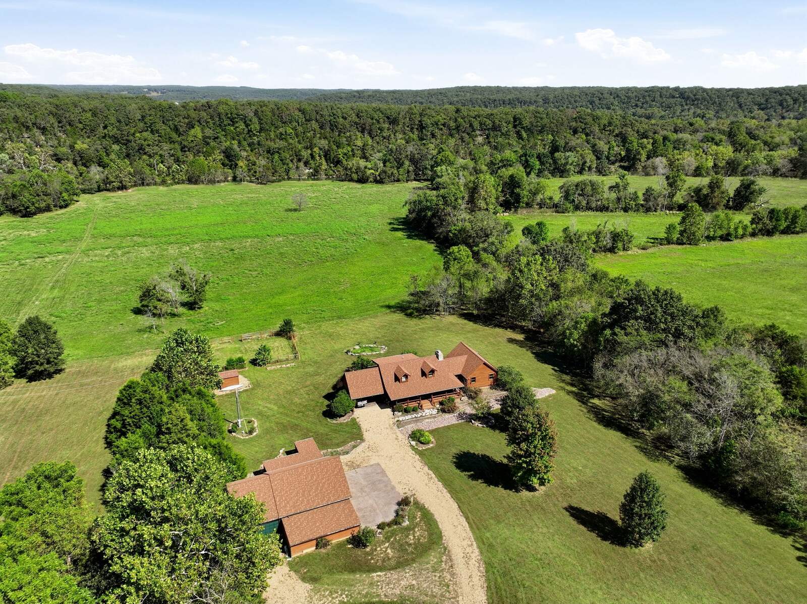 Aerial of the log home, garage, and drive