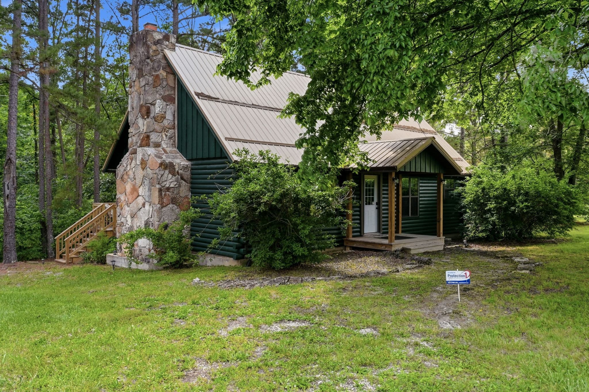 Native stone chimney and covered entry of the cabin