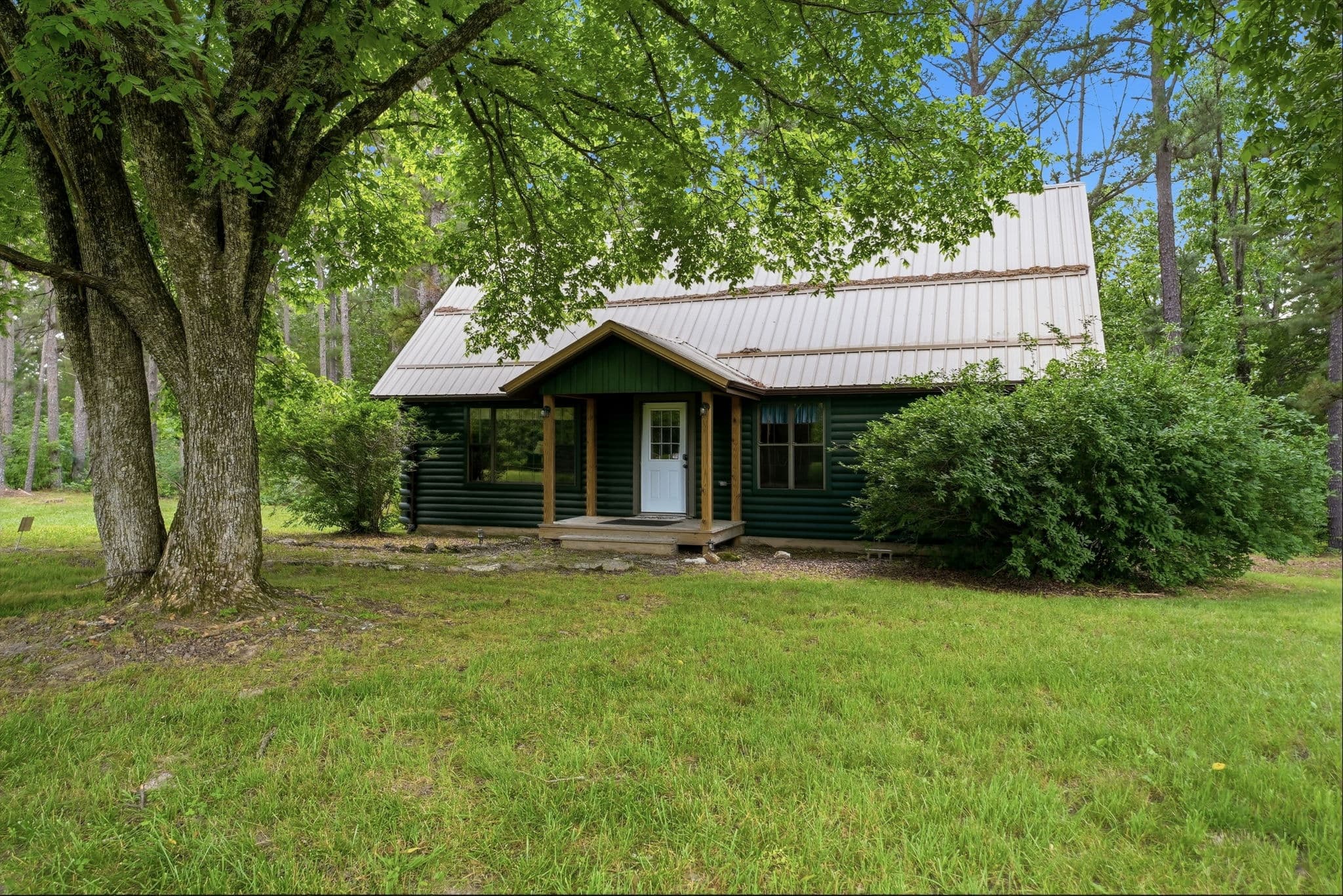 The Private Green Cabin exterior framed by mature Ozark pines