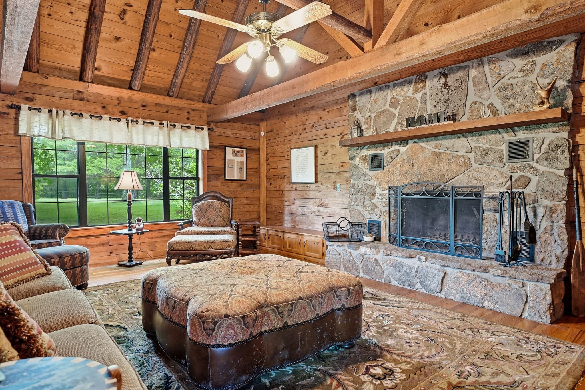 Living room seating beside the stone fireplace