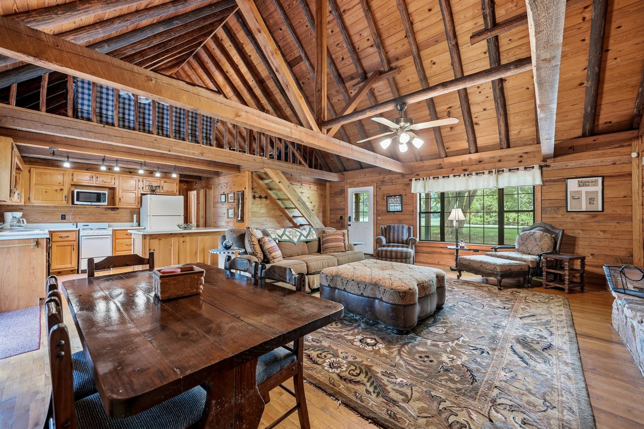 Open living and dining area with loft stairs