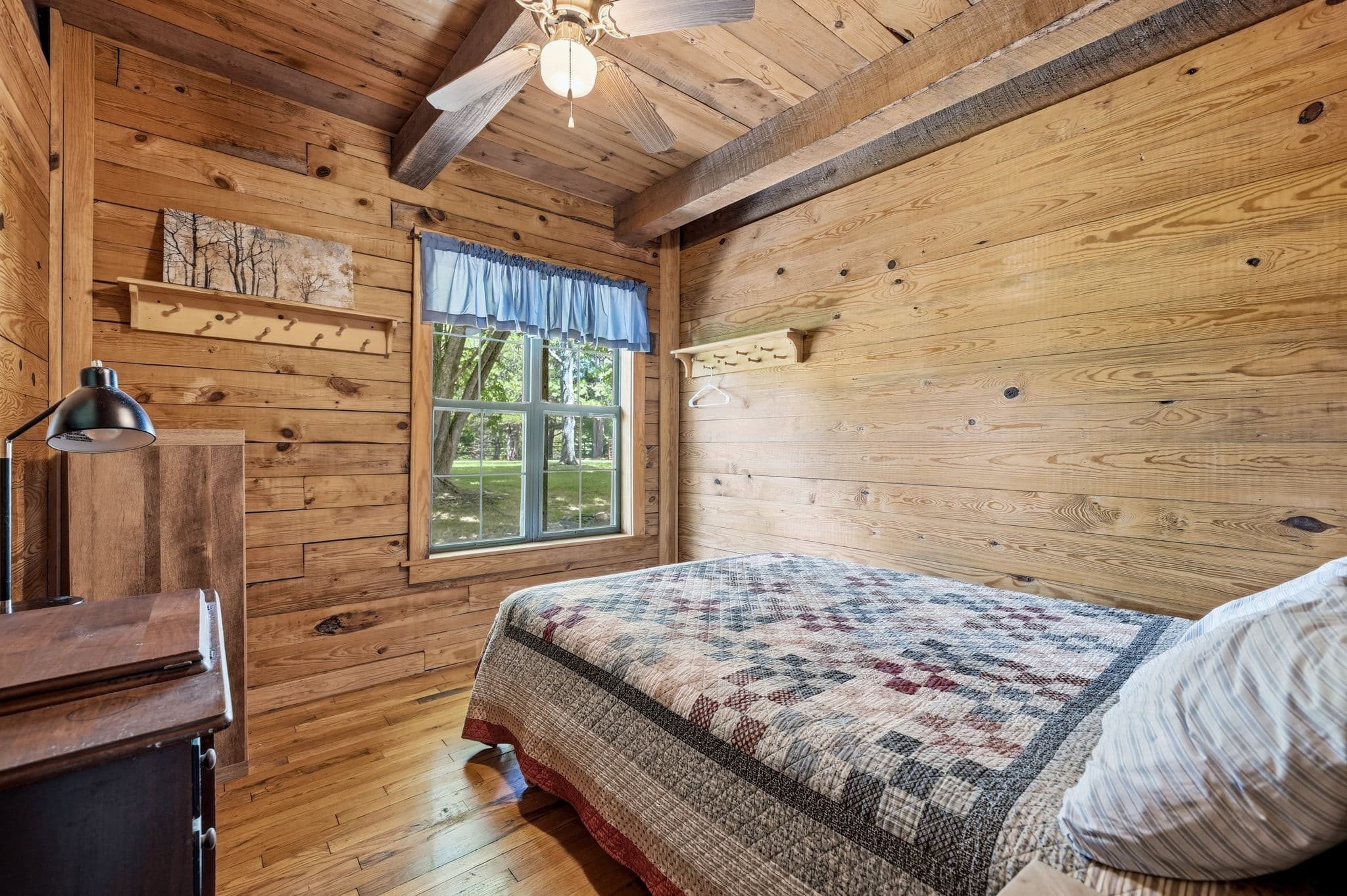 Main bedroom with all-wood walls and vaulted ceiling