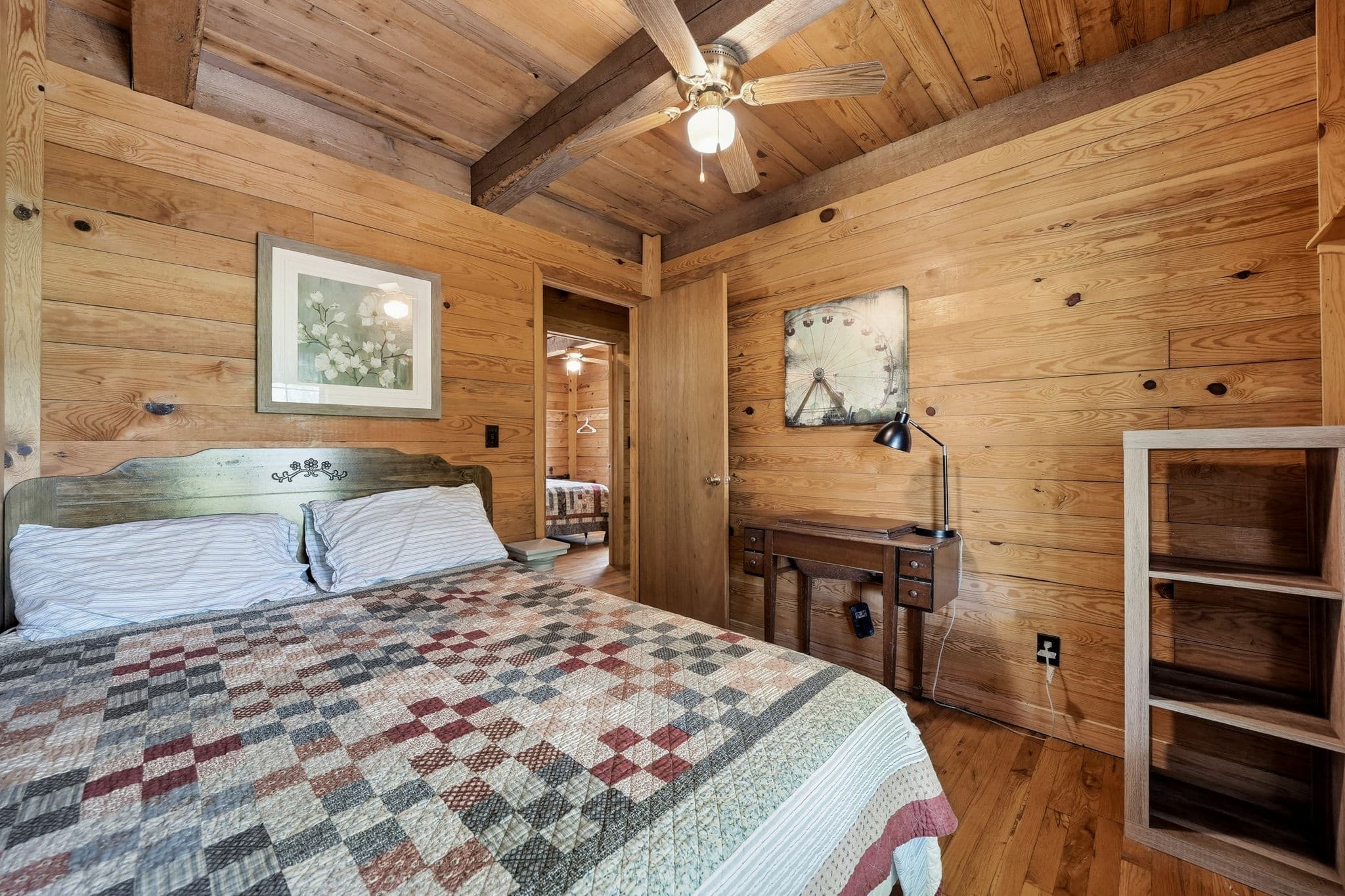 Bedroom with quilted bedding and woodland views