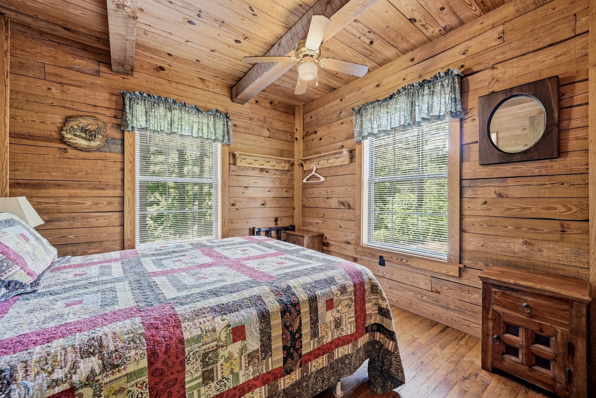 Second bedroom with pine walls and ceiling fan
