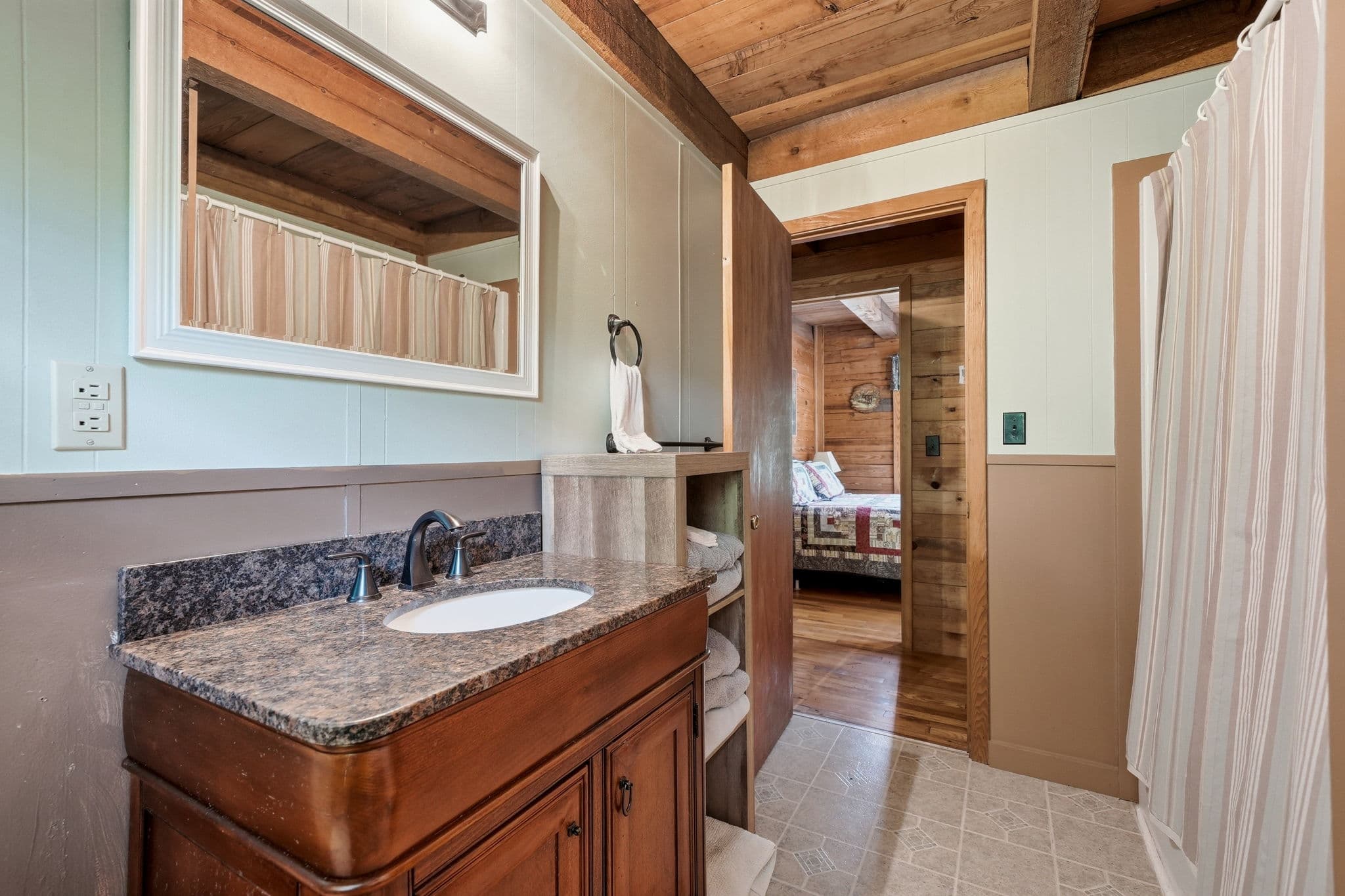 Full bathroom with granite-topped vanity